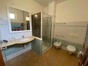 a bathroom with a sink and a shower and a toilet at 103 Boutique Hotel Stintino in Stintino