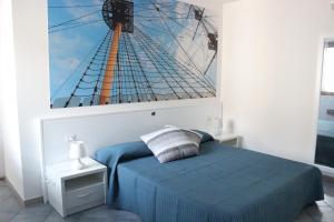 a bedroom with a blue bed and a picture of a ship at 103 Boutique Hotel Stintino in Stintino