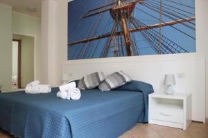 a bedroom with a blue bed with towels on it at 103 Boutique Hotel Stintino in Stintino