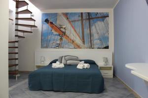 a bedroom with a large painting of a ship on the wall at 103 Boutique Hotel Stintino in Stintino