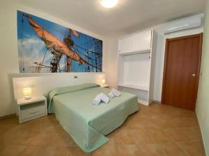 a bedroom with a green bed and a painting on the wall at 103 Boutique Hotel Stintino in Stintino