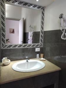 a bathroom with a sink and a large mirror at agriturismo heaven in Capo Vaticano