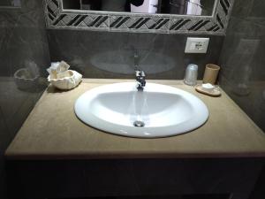 a white sink in a bathroom with a mirror at agriturismo heaven in Capo Vaticano