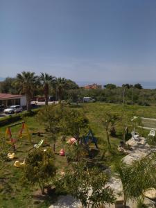 a park with trees and play equipment in the grass at agriturismo heaven in Capo Vaticano
