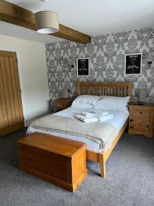 a bedroom with a bed with a wooden frame and a table at Fox and Goat in Waterstock