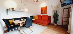 ein Wohnzimmer mit einem roten Sofa und einem Tisch in der Unterkunft Apartment Maier in Radstadt