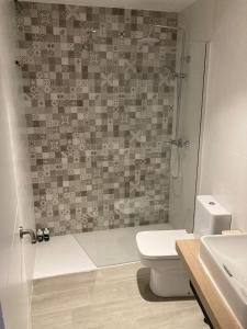 a bathroom with a shower and a toilet and a sink at La Casita del Río - Riverside Home in Cuenca +16 photos