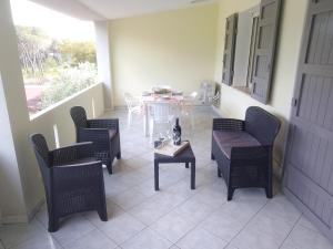 un patio con mesa, sillas, mesa y un taburete en MaRo Apartment, en Cala Liberotto