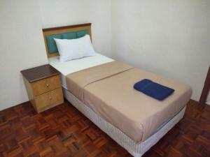 ein Schlafzimmer mit einem Bett und einem blauen Handtuch darauf in der Unterkunft Lumut Valley in Lumut