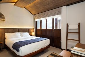 Baan Kamana Guest House في فانجنجا: غرفة نوم بسرير كبير ونافذة