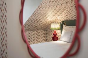 a mirror reflection of a bedroom with a bed and a lamp at The Sparrow Hotel in Stockholm