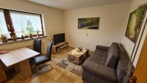 a living room with a couch and a table at Ferienwohnung im Sauerland - nähe Olpe (Biggesee) in Drolshagen