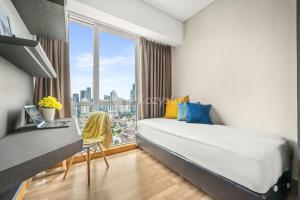 a bedroom with a bed and a desk and a window at London by Kozystay - Setiabudi in Jakarta +18 photos