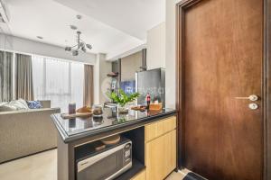 a kitchen with a counter top and a wooden door at LONDON by Kozystay - Kuningan in Jakarta
