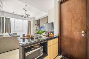 a kitchen with a counter top and a wooden door at London by Kozystay - Setiabudi in Jakarta