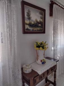 un jarrón con flores en una mesa en una habitación en Precioso apartamento en San Vicente de O Grove, en San Vicente de O Grove
