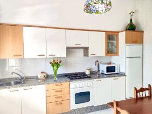cocina con armarios blancos y fogones en Precioso apartamento en San Vicente de O Grove, en San Vicente de O Grove