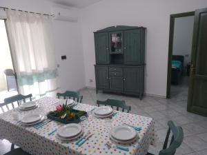 a dining room with a table and a green cabinet at MaRo Apartment in Cala Liberotto +13 photos
