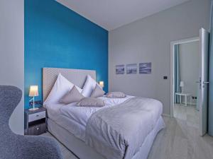 um quarto com uma cama grande e uma parede azul em Panorama-Utkiek em Wustrow