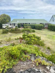 a house with a yard with plants in front of it at Fairhill Farm in Gansbaai