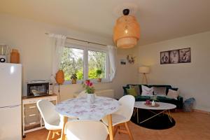 cocina y sala de estar con mesa y sillas en Bungalow am Waldesrand/ Haus Konrad, en Suhl