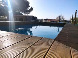 a swimming pool with the sun shining on the water at Renovated Wine Press House - WITH POOL in Porto de Mós