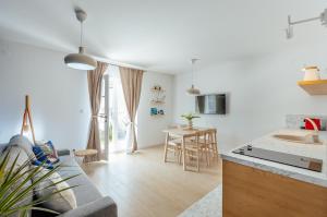 Il dispose d'une cuisine et d'un salon avec un canapé et une table. dans l'établissement Magnolia Apartments 2 Herceg Novi, à Herceg-Novi