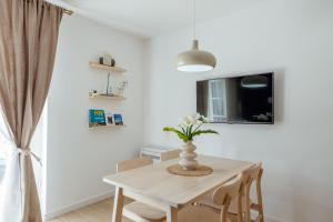 a dining room table with a vase of flowers on it at Magnolia Apartments 2 Herceg Novi in Herceg-Novi