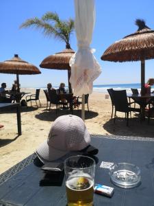 stół z kapeluszem i okularami na plaży w obiekcie Casa Alma w mieście Conil de la Frontera