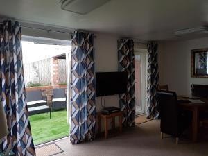 a living room with curtains in front of a window at 1, The Mews in Derby