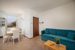 a living room with a blue couch and a table at Casa Sole in Varenna