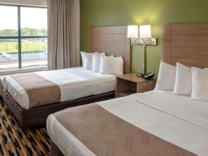 a hotel room with two beds and a window at Quality Suites Lake Wright Norfolk Airport in Virginia Beach
