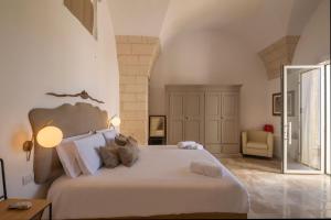 a bedroom with a large white bed and a chair at Dimora Oru in Lecce
