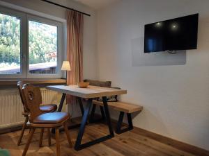 a room with a table and a tv on the wall at Ferienhaus Anna in Sölden