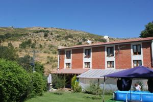 un edificio con un paraguas azul delante de él en Las Tejeruelas Casa Rural, en Navacepedilla de Corneja