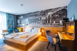 a bedroom with a large bed and a desk and a desk at mightyTwice Hotel Dresden in Dresden