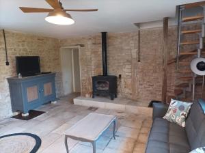 a living room with a fireplace and a couch and a stove at La maison du meunier avec terrain de pétanque in Autigny-la-Tour