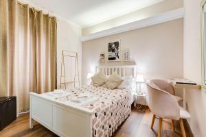 a white bedroom with a bed and a chair at JMartins Roma Suites in Rome