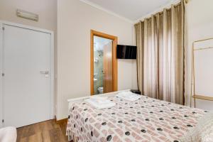 a bedroom with a bed and a mirror at JMartins Roma Suites in Rome