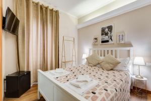 a bedroom with a large bed and a television at JMartins Roma Suites in Rome