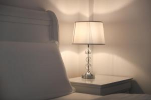 a lamp sitting on a table next to a bed at Perla Sudului - Residence in Timişoara
