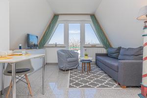 a living room with a couch and a table at Meer Appartement in Büsum