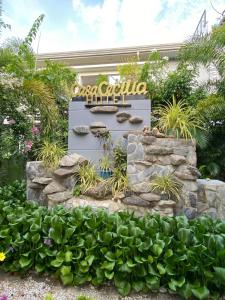 un cartello per l'ingresso di un hotel con piante di Casa Cecilia Hotel a Bantay