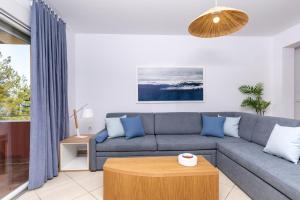 un soggiorno con divano e tavolo di PineReef Blue a Skala Rachoniou