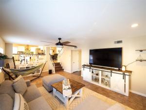 a living room with a couch and a flat screen tv at Spacious house with pool heater, hot tub, billiards in Phoenix