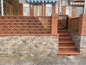 a house with a brick fence and stairs in front at Accogliente Appartamento Costa Makauda in Ribera