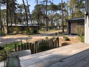 a wooden table and chairs in a yard at Natuurhuisje Pine & Oak 6 persoons in Hardenberg