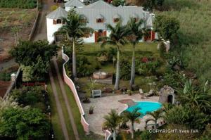 an aerial view of a house with a swimming pool at Ferme équestre des Avirons in Les Avirons