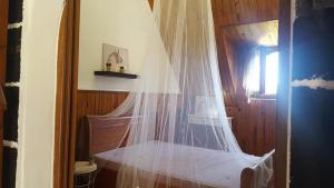a bedroom with a bed with a mosquito net at Ferme équestre des Avirons in Les Avirons