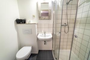 a bathroom with a toilet and a sink and a shower at Gosciniec Szuwary in Krutyń